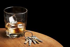 Glass of alcohol and keys on a table